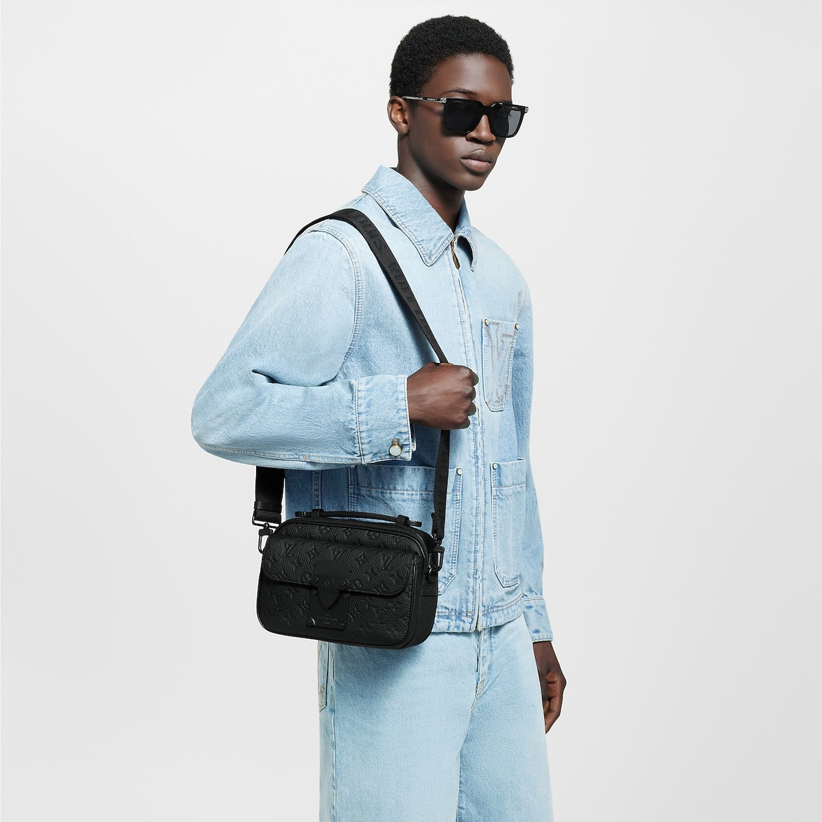 sac messenger S Lock de Louis Vuitton se distingue par son cuir Taurillon noir orné du motif Monogram embossé et sa serrure magnétique distinctive inspirée des malles de la Maison.